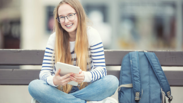 girl sitting on a bench and smiling